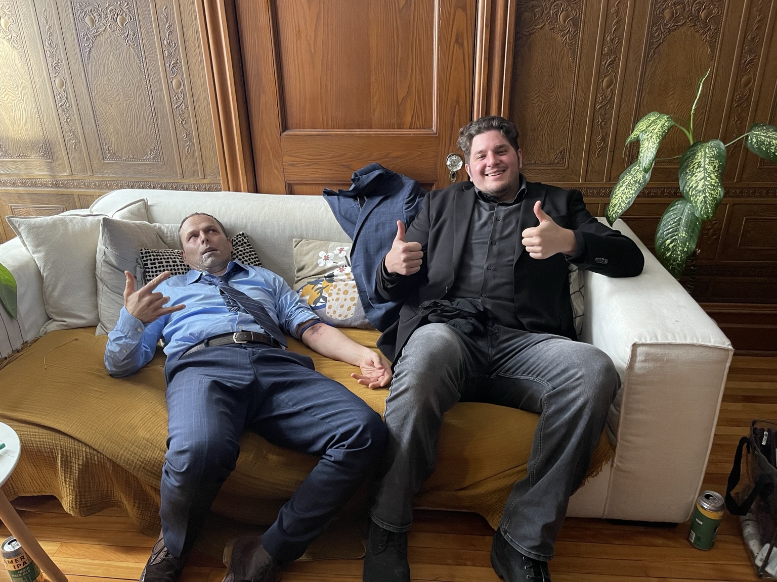 La Collecte — pause entre les prises Martin Blais allongé sur un canapé en costume pendant une pause du tournage de La Collecte, avec un collègue à ses côtés